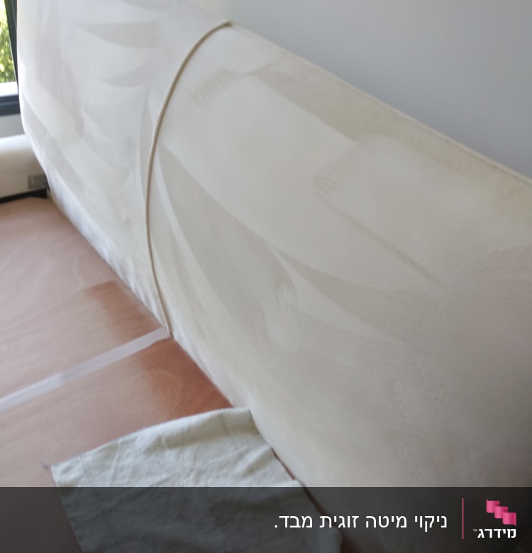 ספה לבנה עם כתמים, מטלית על הרצפה